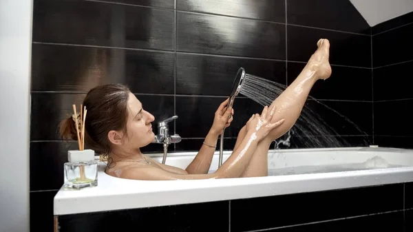 一种有温泉般的经历的女性 在温和的淋浴下 以一种轻松的方式洗澡和洗脚 自我照顾和放松 — 图库照片