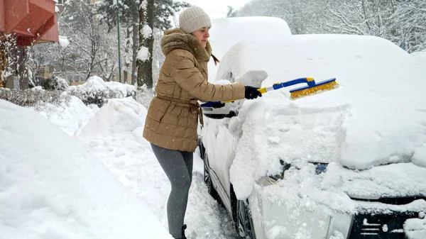 Молодая Женщина Чистит Машину Щеткой Снега После Метели Парковке Концепция — стоковое фото