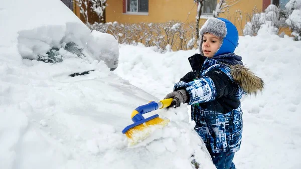 Młody Chłopiec Szczęśliwie Usuwał Śnieg Samochodu Rodziców Szczotką Mroźny Zimowy — Zdjęcie stockowe