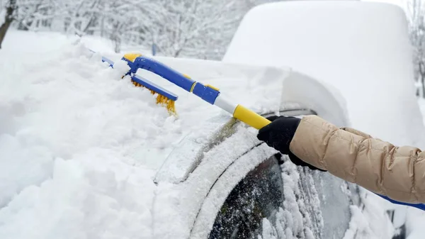 Zbliżenie Kobiety Używającej Szczotki Śnieżnej Usuwania Śniegu Przedniej Szyby Samochodu — Zdjęcie stockowe