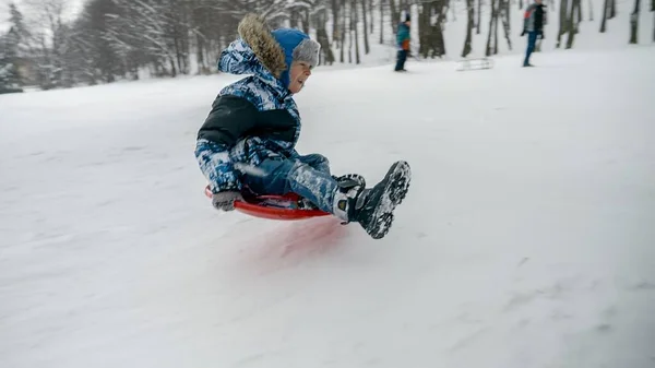 Young Boy Laughing Smiling While Sledding Snowy Hill Jumping Trampoline — Stock Photo, Image