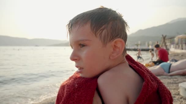 Portret Chłopca Zmarzniętego Kąpieli Morzu Owinięciu Czerwony Ręcznik Wakacje Letnie — Wideo stockowe