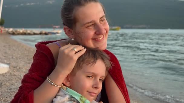 Młoda Kochająca Matka Przytula Swojego Synka Przykrywając Ręcznikiem Plażowym Czując — Wideo stockowe