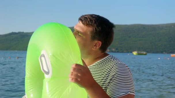 Молодой Человек Любовью Надувает Надувное Плавательное Кольцо Своих Детей Пляже — стоковое видео