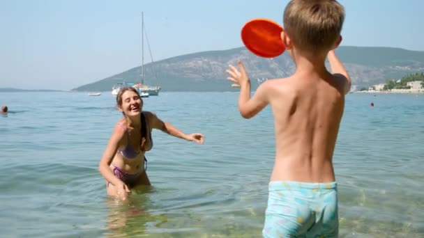 Powolny Ruch Małego Chłopca Rzucającego Frisbee Swojej Matce Stojącej Morzu — Wideo stockowe