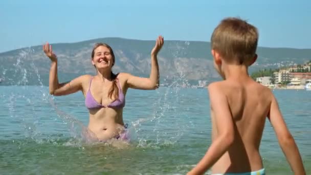 Медленное Движение Счастливая Смеющаяся Мать Сыном Плещут Морскую Воду Веселятся — стоковое видео