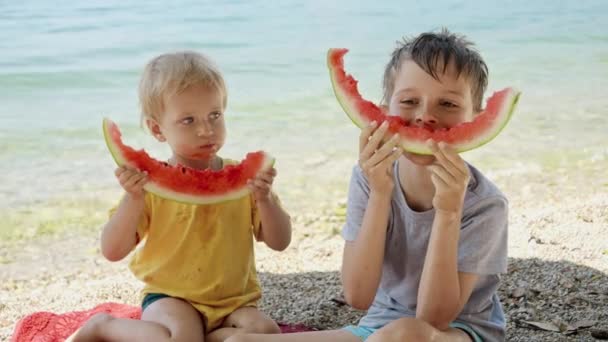 Två Roliga Pojkar Sitter Stranden Och Har Kul Med Vattenmelonsköljningar — Stockvideo