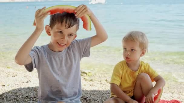 Dos Chicos Sonrientes Disfrutando Comiendo Sandía Jugando Con Cortezas Playa — Vídeo de stock