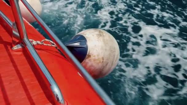寒い北海を航行する赤い救助ボートの側にぶら下がるフェンダーとブイのクローズアップ — ストック動画