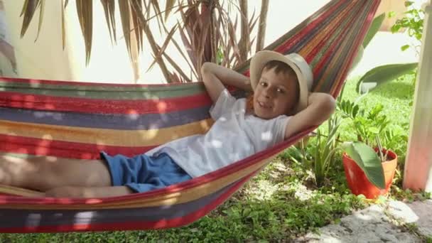 Spokojnym Ogródku Szczęśliwy Chłopiec Zakłada Okulary Przeciwsłoneczne Podczas Gdy Doświadcza — Wideo stockowe