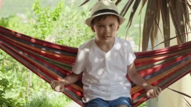 Vibes Διακοπές Αγόρι Σαλόνια Καπέλο Στην Αιώρα Κήπο Απολαμβάνοντας Ξέγνοιαστες — Αρχείο Βίντεο