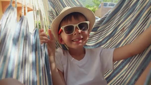 Молодой Мальчик Шляпе Блаженно Покачиваясь Гамаке Истинное Изображение Беззаботного Отдыха — стоковое видео