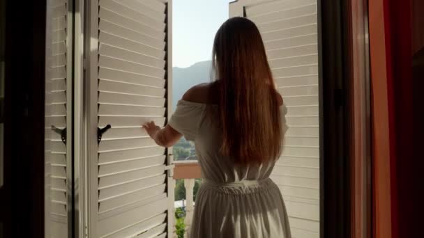 Wanita Berambut Cokelat Muda Membuka Tirai Jendela Vilanya Dan Berjalan — Stok Video
