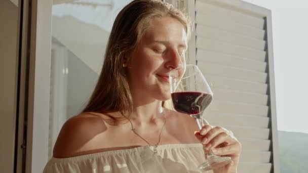 Portret Pięknej Brunetki Cieszącej Się Kieliszkiem Czerwonego Wina Stojącej Drzwiach — Wideo stockowe