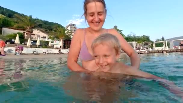 Χαρούμενο Γελαστό Αγοράκι Μαθαίνει Κολύμπι Στη Θάλασσα Μητέρα Οικογενειακές Διακοπές — Αρχείο Βίντεο