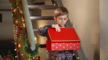 Pijamalı küçük çocuk Noel Baba 'nın hediyesiyle Noel hediyesini açtıktan sonra üzgün ve tatminsiz oldu. Kışın ve yeni yılda üzüntü, depresyon, yalnızlık ve negatif duygular.