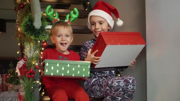 Dwóch Wesołych Chłopców Piżamie Śmiejących Się Podekscytowanych Otrzymaniu Prezentów Świątecznych — Wideo stockowe