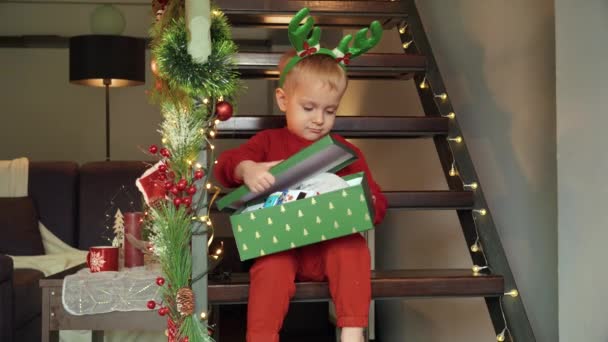 Cute Little Boy Otwiera Pudełko Prezentów Świątecznych Ekscytować Się Jego — Wideo stockowe