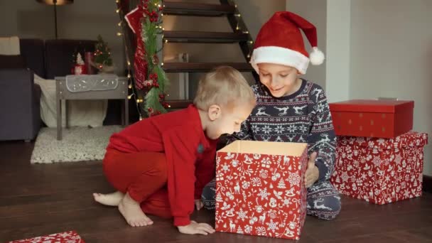 Dva Šťastní Nadšení Kluci Pyžamu Sedí Dřevěné Podlaze Otevírají Vánoční — Stock video
