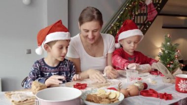 Noel sabahı çocuklar Noel Baba 'ya kurabiye pişirip hazırlarken mutlu bir aile. Kış tatili, kutlamalar ve parti.