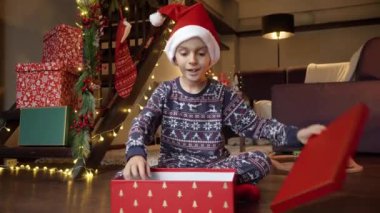 Mutlu heyecanlı çocuk Noel Baba 'dan bir Noel hediyesi olarak tablet bilgisayar aldıktan sonra mutlu olur ve gülümser. Kış tatili, kutlamalar ve parti.