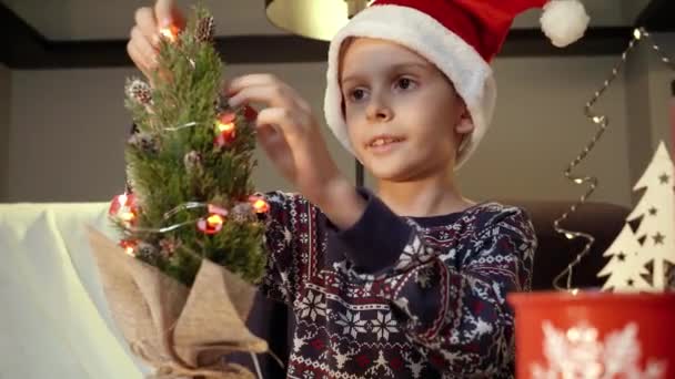 Menino Sorridente Feliz Desfrutando Decorar Árvore Natal Com Luzes Guirlandas — Vídeo de Stock