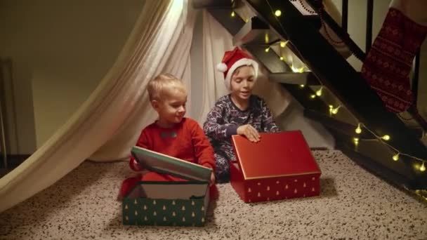 층계의 Tepee 천막에서 산타에게서 크리스마스 그리고 선물을 잠옷에 2명의 쾌활한 — 비디오