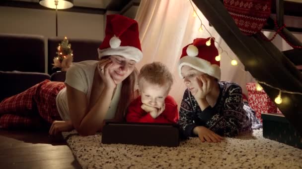Feliz Familia Celebrando Navidad Tumbada Suelo Viendo Vídeo Tableta Sala — Vídeo de stock