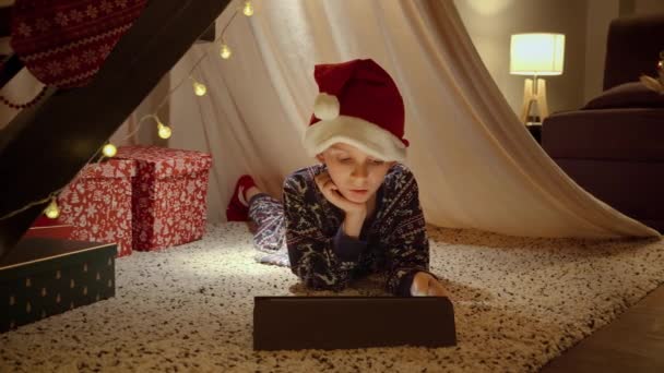 Ragazzino Pigiama Cappello Babbo Natale Che Celebra Natale Sdraiato Tenda — Video Stock