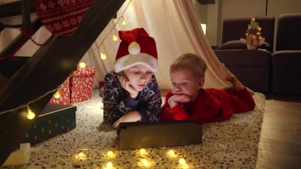 Dois Irmãos Pijama Comemorando Natal Deitados Chão Assistindo Vídeos Computador — Vídeo de Stock
