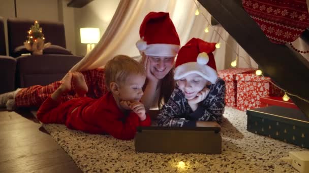 Oğlu Yerde Yatan Noel Gecesi Tablet Bilgisayar Kullanan Mutlu Bir — Stok video