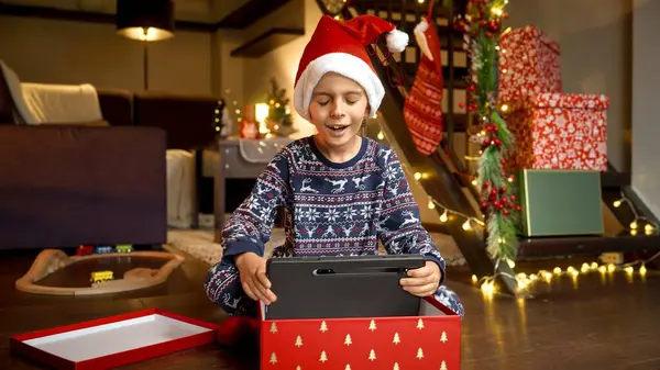 Joyeux Garçon Souriant Pyjama Ouvre Boîte Cadeau Noël Prend Tablette — Photo