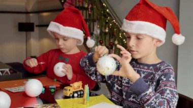 İki çocuğun portresi ve Noel süsleri süsleyip süslemesi. Kış tatili, aile zamanı, aileleri kutlama yapan çocuklar.