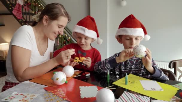 Kinder Mit Mutter Bemalen Und Dekorieren Weihnachtskugeln Wohnzimmer Winterurlaub Familienzeit — Stockvideo