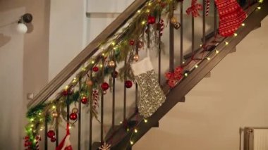 Geceleri pijamalı küçük bir çocuk Noel ya da yeni yıl kutlamaları için dekore edilmiş evin ahşap merdivenlerinden iniyor..