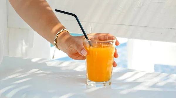 Closeup Elegant Woman Stirring Her Orange Juice Straw Drinking While — Stock Photo, Image