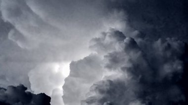 Koyu mavi ve gri bulutlar gök gürültüsü ve sağanak yağmurdan önce yanıp sönüyor..