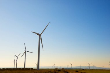 Rüzgar türbinleri günbatımında sürdürülebilir elektrik üretimi için jeneratörler üretiyor