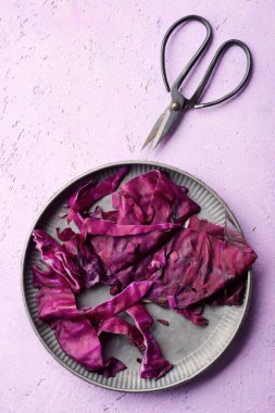 Metal bir tabakta kırmızı lahana yaprakları kes.