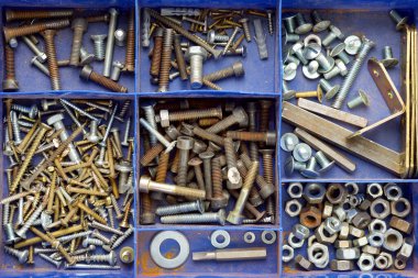 Mavi plastik bir kutunun içinde geniş bir vida ve diğer metal donanım grubu kapatın