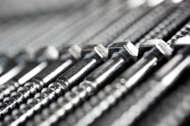 Bir masadaki birçok metal metrik altıgen vidaların yakın plan görüntüsü.