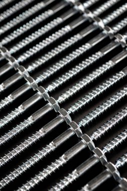 Bir masadaki birçok metal metrik altıgen vidaların yakın plan görüntüsü.