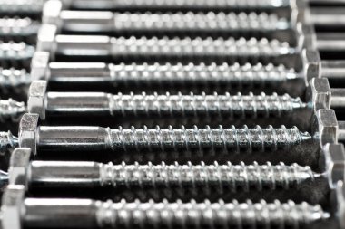 Bir masadaki birçok metal metrik altıgen vidaların yakın plan görüntüsü.