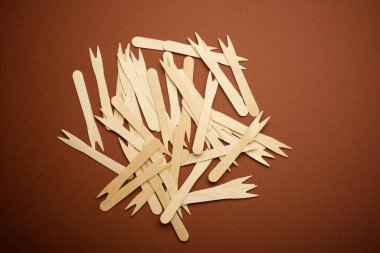 Kahverengi bir masanın üzerinde tek kullanımlık ahşap çatallar.