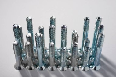 Bir masadaki birçok metal metrik altıgen vidaların yakın plan görüntüsü.