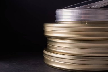 Siyah bir masanın üzerindeki bir grup film kutusunun yakın plan fotoğrafı.