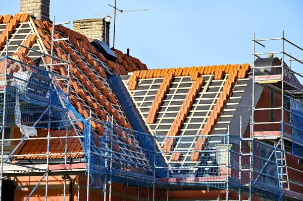 Çatıda kırmızı kiremitler yığılmış. Kumla İsveç 10 Şubat 2023