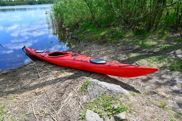 美しい湖クムラスウェーデンの近くの土地に赤いプラスチックカヤック5月31 2023 — ストック写真