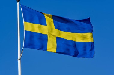 Swedish flag on flag pole and clear blue sky on national day june 6 2023 Kumla Sweden clipart