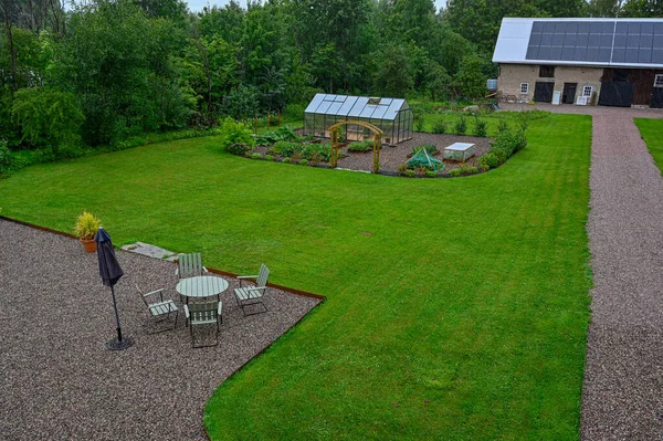 Looking out over back garden with seating area and green house Kumla Sweden august 2 2023